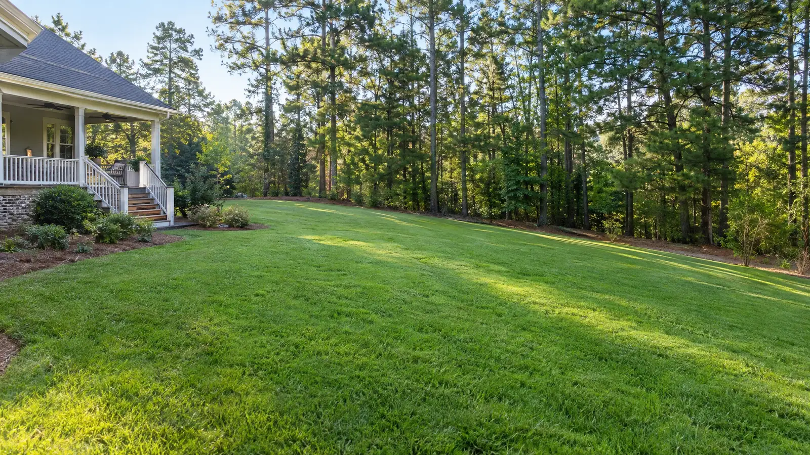 Before: A sloped yard before and after a stepped playset with a hill slide